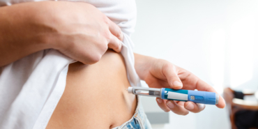 Person administering insulin injection using a pen